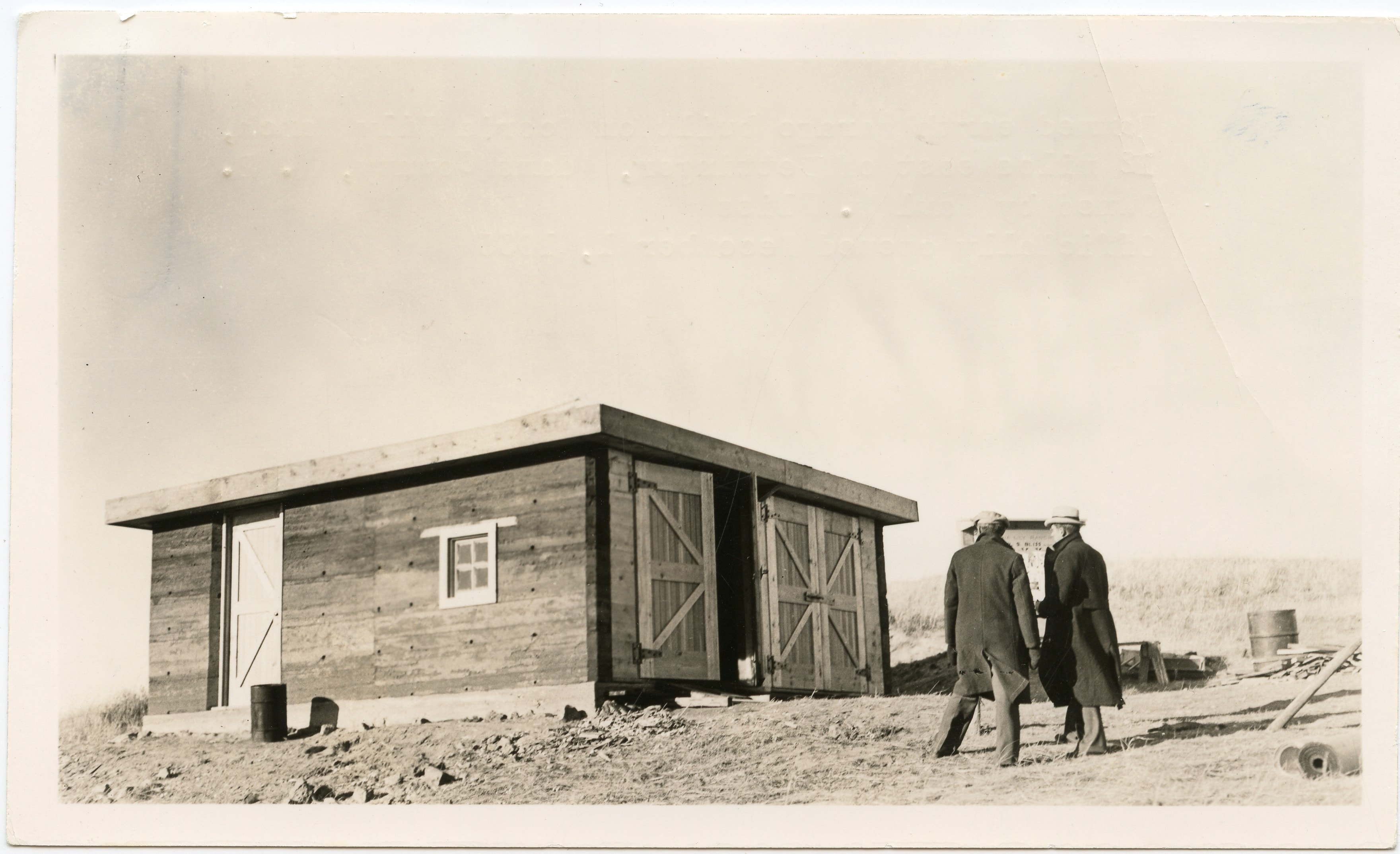 Two figures approach the newly completed Scoria Lily Ranch garage, c. 1936